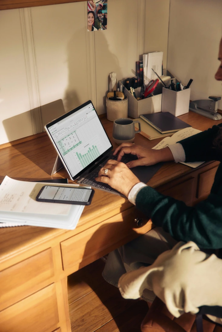 Dirigeante consultant un tableau de suivi des dépenses et un graphique sur sa tablette, à son bureau